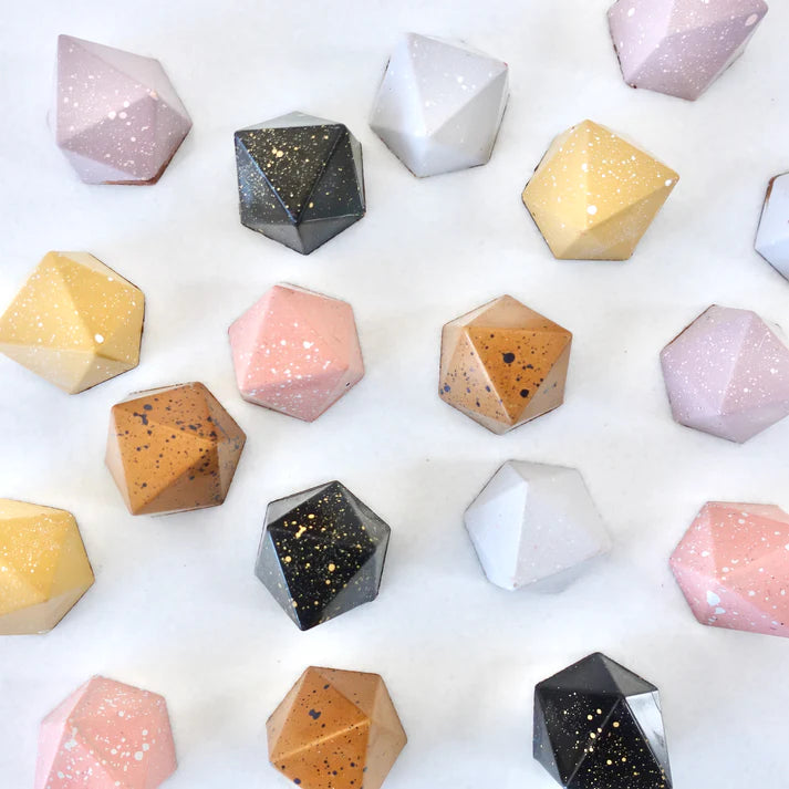 Geometrically shaped soap bars in various colors on a white background